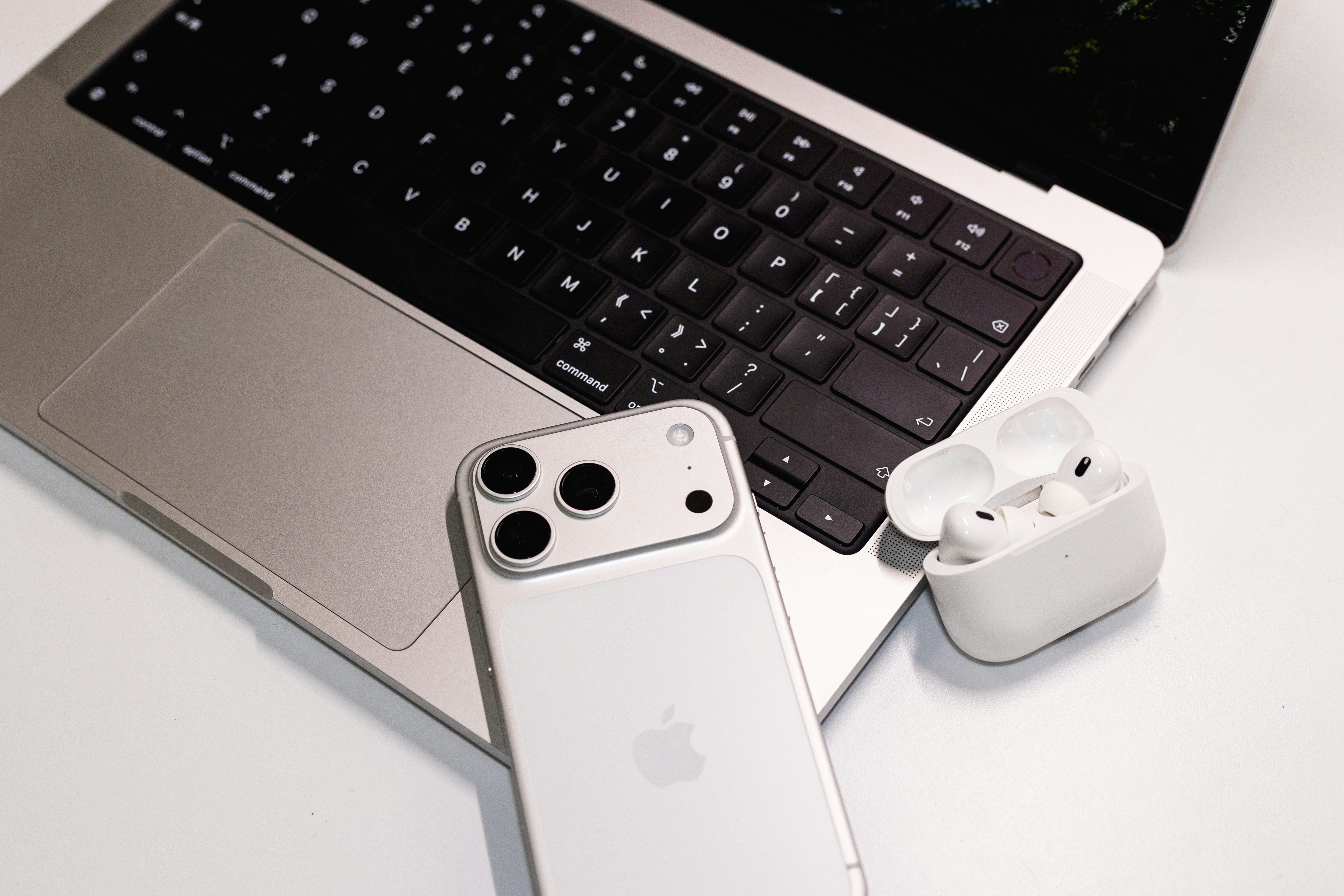 Laptop with phone and earbuds on a desk